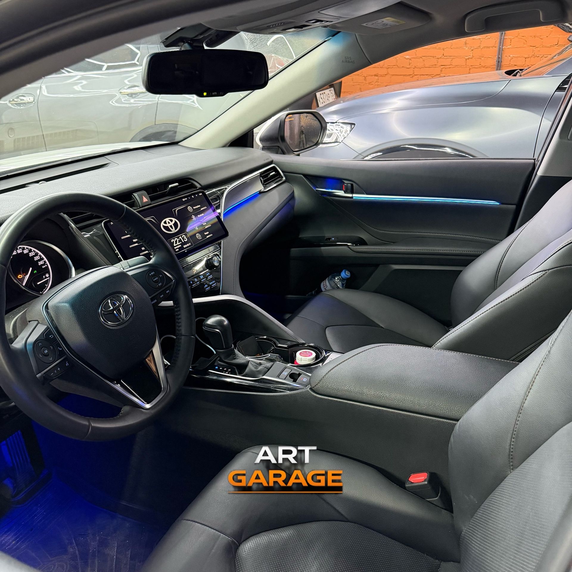 Салон Toyota Camry с установленной магнитолой и атмосферной подсветкой
